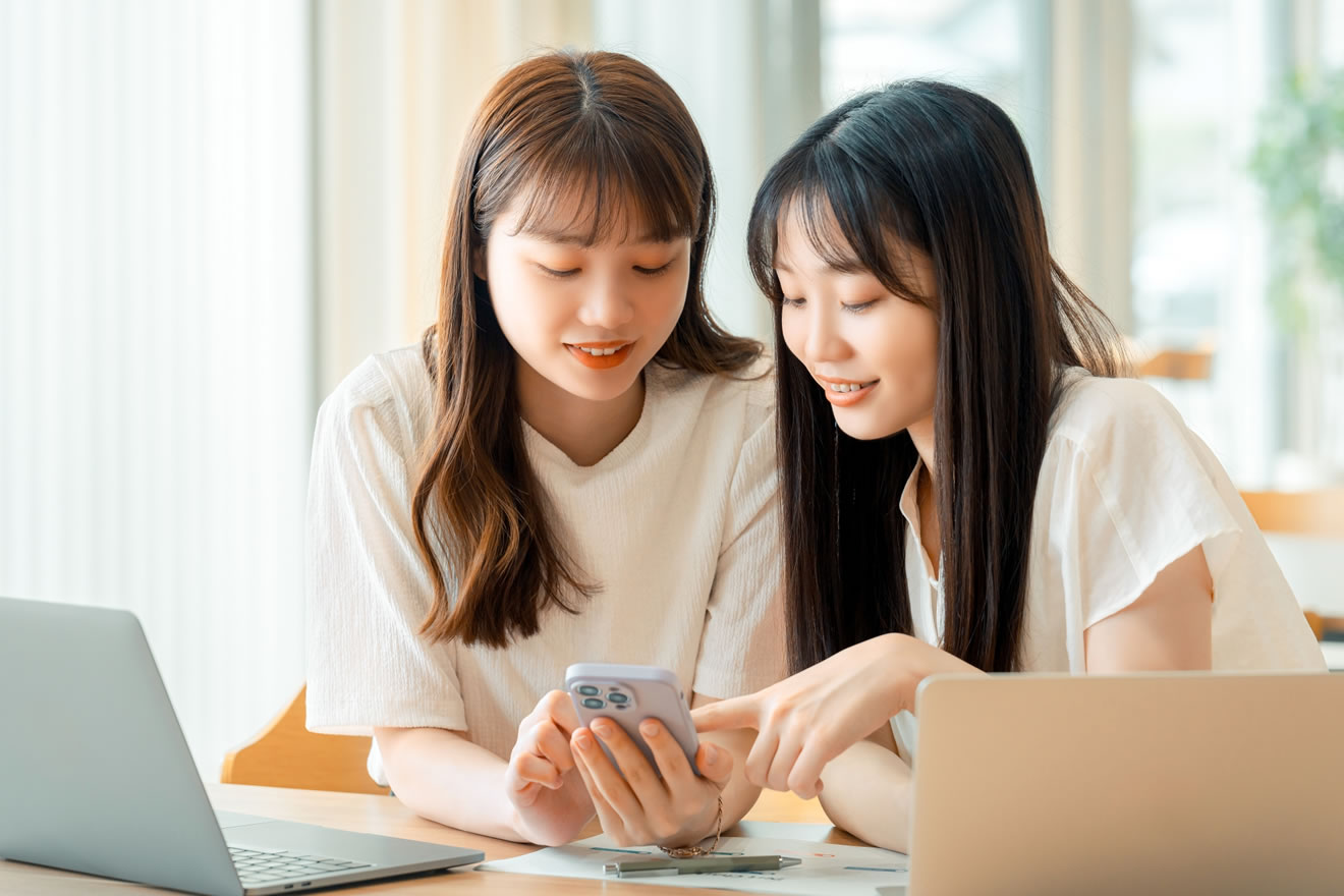 採用サイトを見る笑顔の女性2人