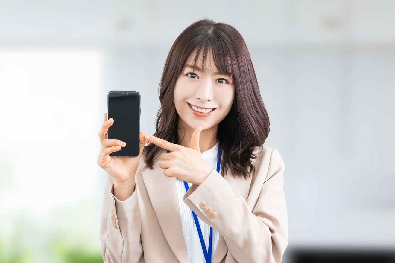 スマートフォンを指差しする女性