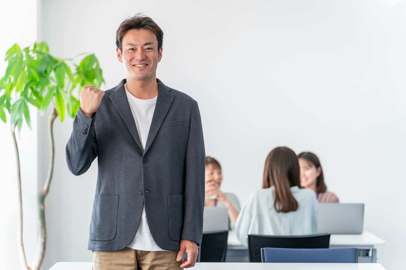 職場でガッツポーズする男性